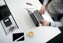 person using laptop on white wooden table